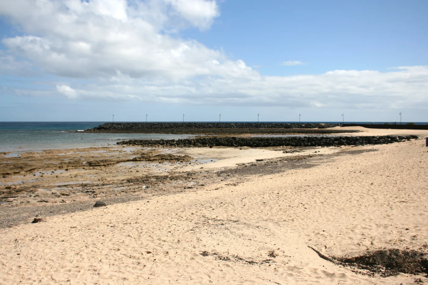 Pale sand, volcanic rock and sheltered water at Playa de los Charcos in Costa Teguise.