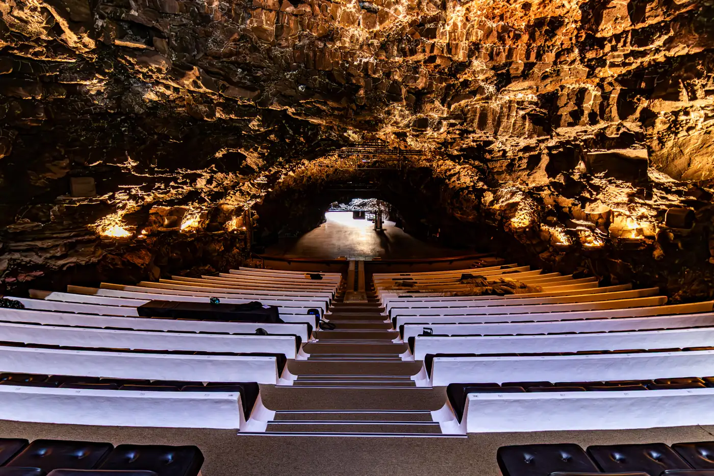 Rows of white seats in the auditorium inside the volcanic tube at Jameos del Agua.
