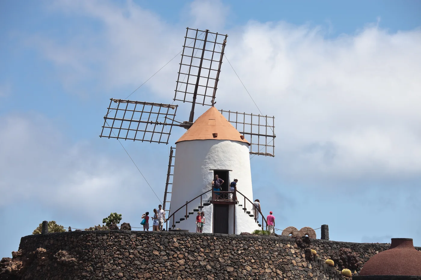 The white windmill at the top of the Jardín de Cactus, above walls of volcanic stone.