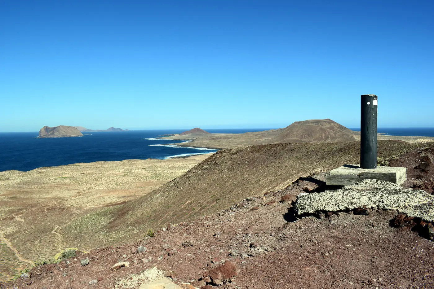 The view from the top of Montaña Amarilla over La Graciosa's coast, with islets offshore.