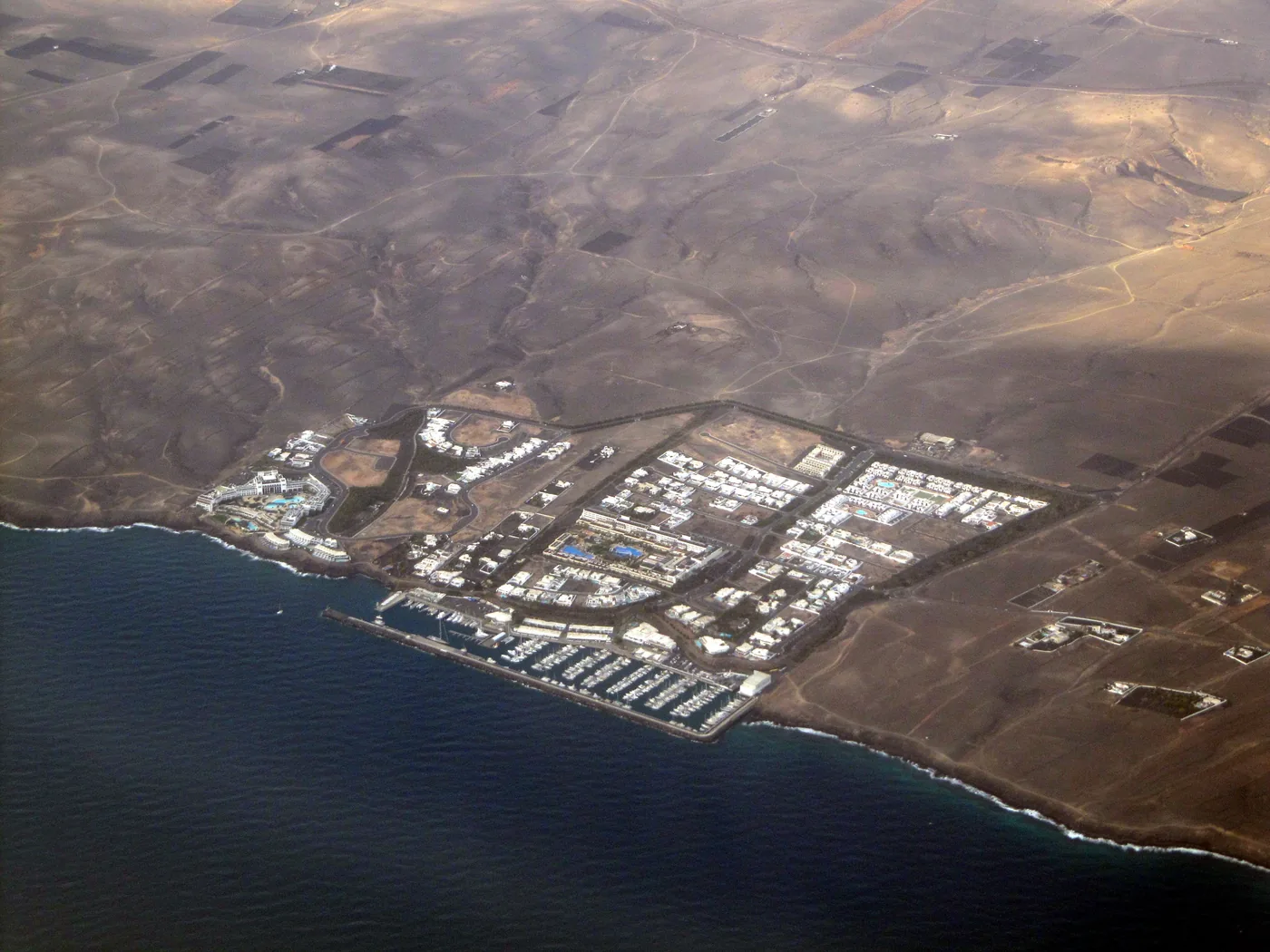 Aerial view of Puerto Calero's marina and white buildings on the dry south coast of Lanzarote.