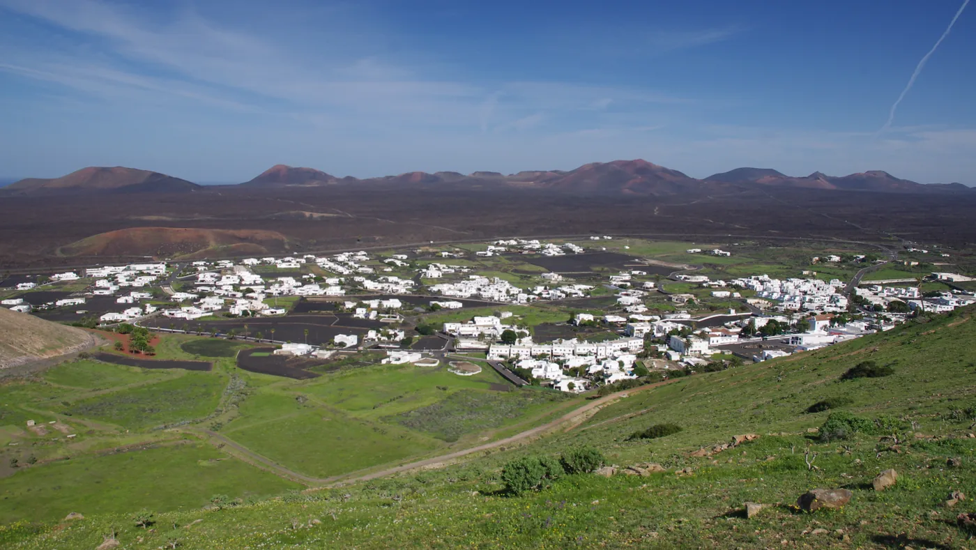 The town of Yaiza seen from above, among fields and volcanic hills.